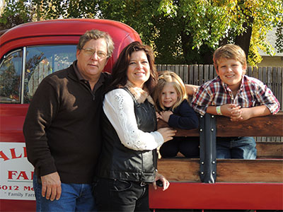 The Allard family poses on the famous Allard Farms red truck at a farm market near Stockton, California.